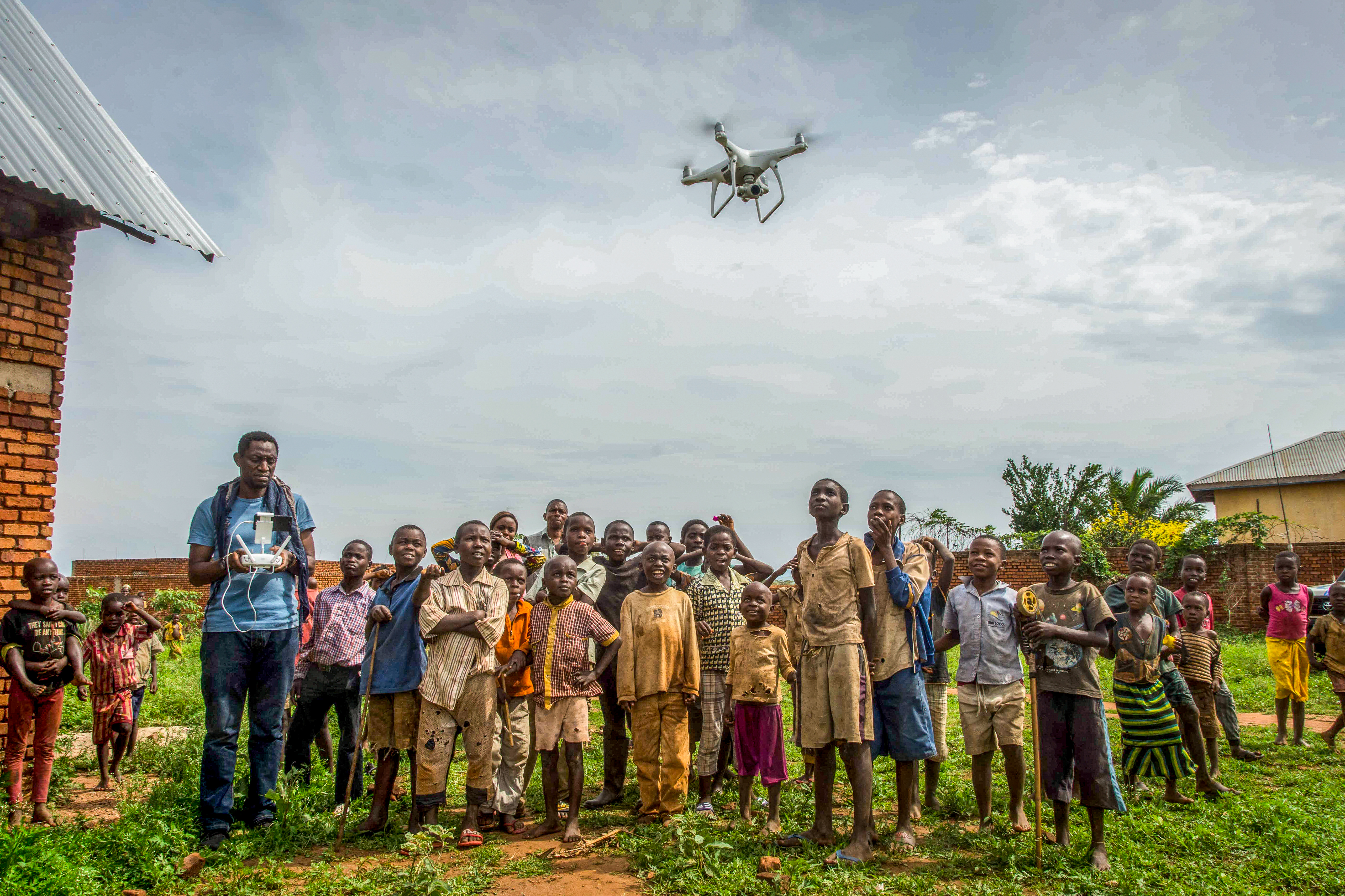 Children in the Democratic Republic of Congo look up to a drone flying over their heads.